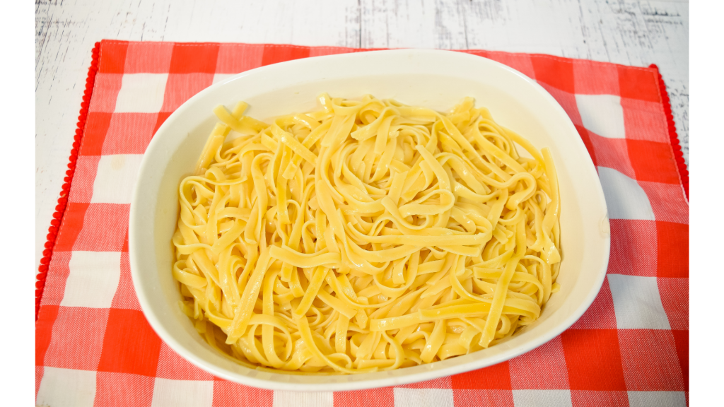 Cooked fettuccine noodles in white bowl.