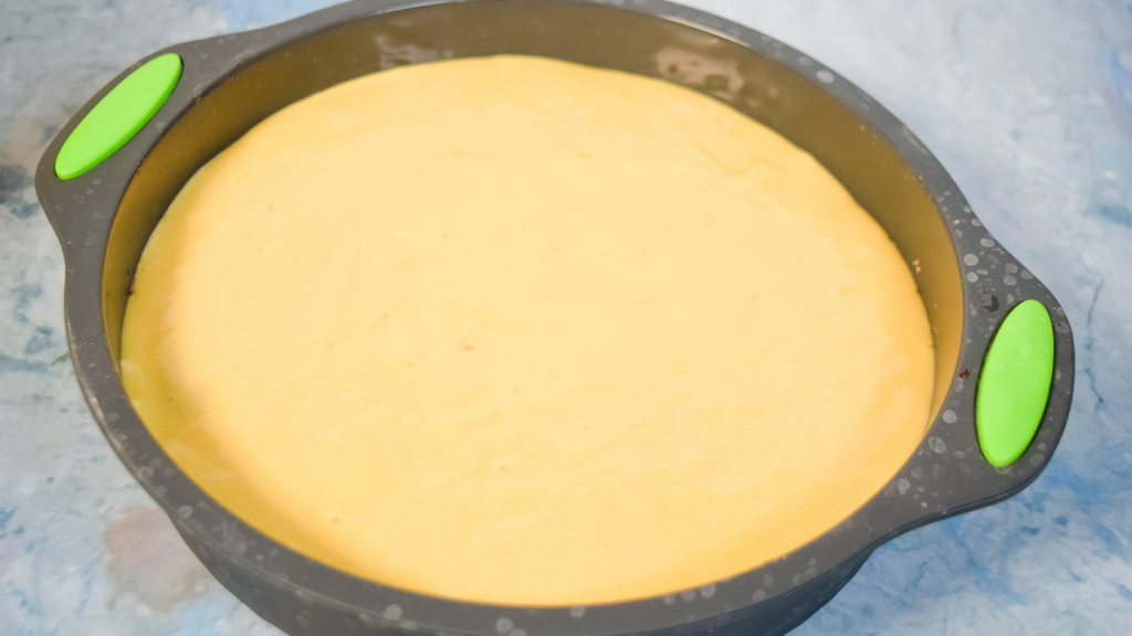 A gray silicone cake pan with yellow cake batter. 