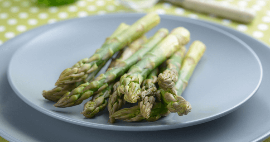 Asparagus freshly steamed from the microwave on a blue plate