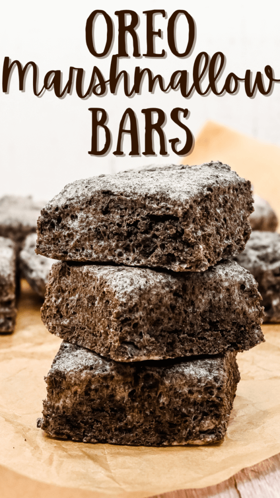 Title image with a close up of three OREO Marshmallow Bars stacked on top of each other on brown parchment paper. 