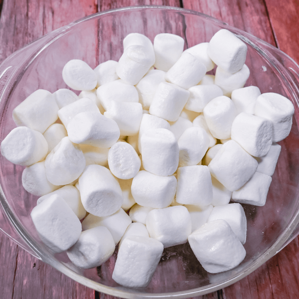 A glass bowl full of marshmallows. 