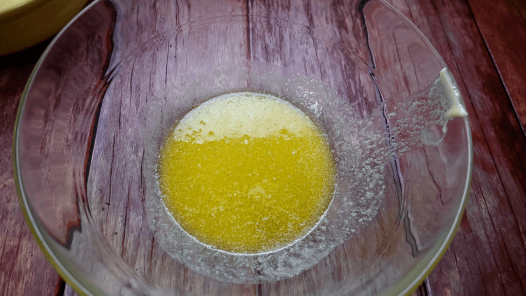A glass bowl on a brown table with melted butter