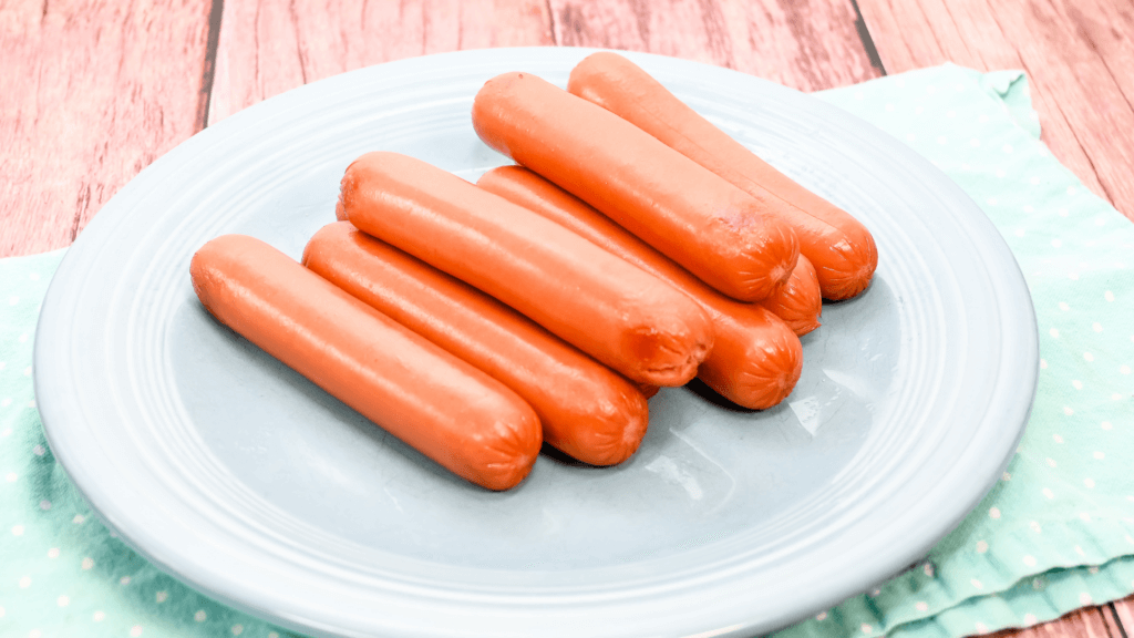 8 hot dogs just microwaved on a blue plate