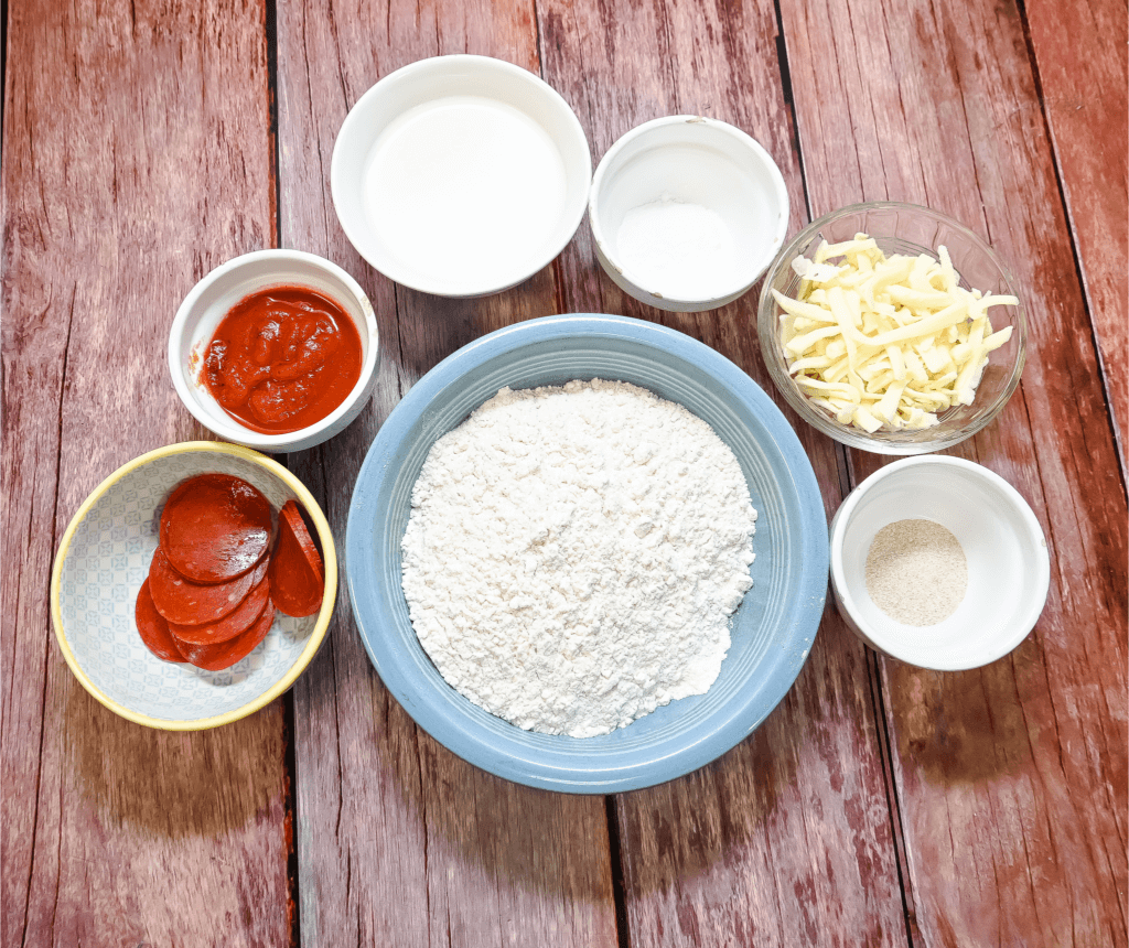 Ingredients to make Microwave Pizza on a wooden tabletop