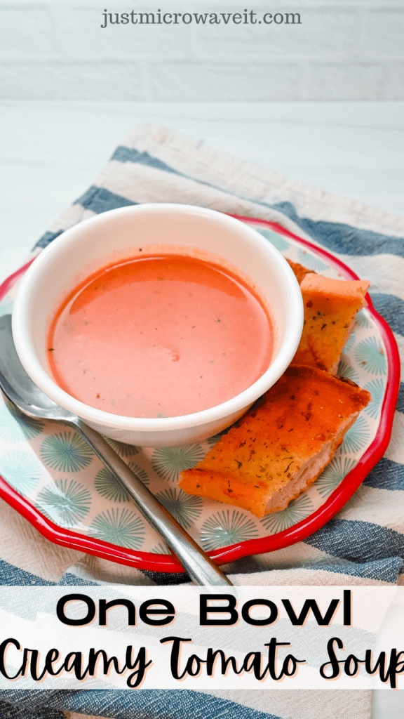 Title image with a white bowl of creamy tomato soup on a red rimmed plate with a spoon and garlic toast. 