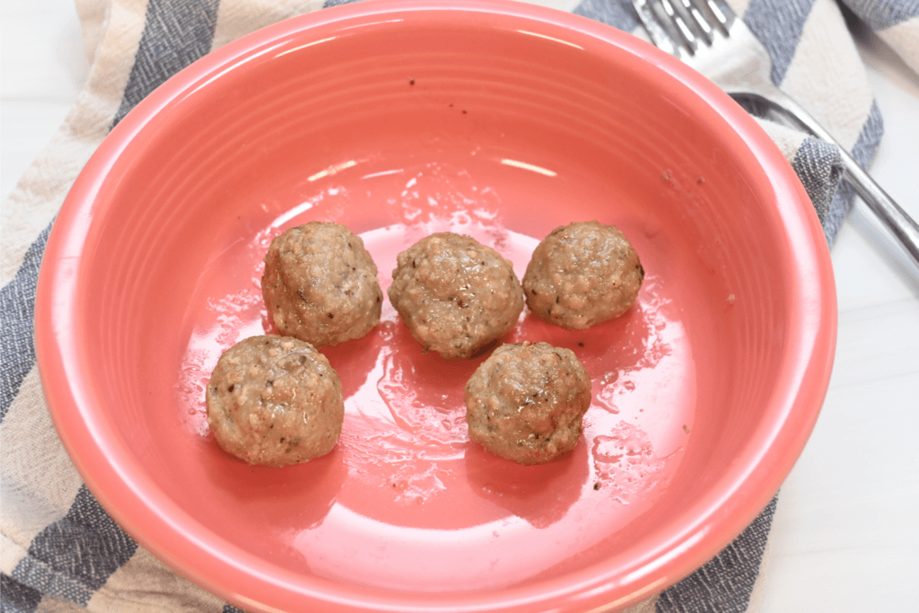 Frozen meatballs in a salmon colored bowl