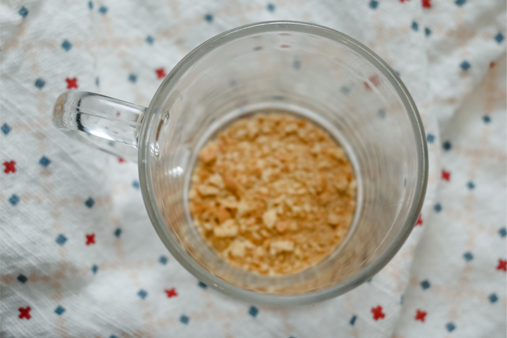 Close up of crushed graham crackers in a clear mug