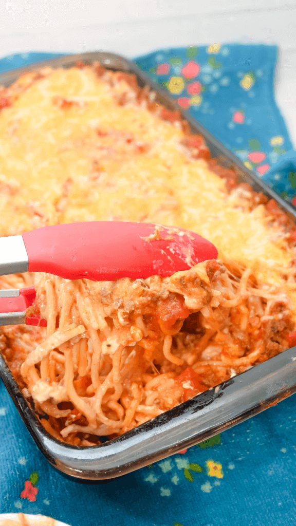 Red tongs holding up some Mexican Spaghetti