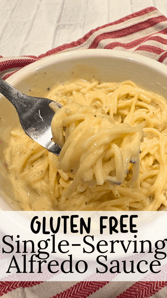 A white bowl of spaghetti with gluten-free alfredo sauce on a red and white striped towel. 