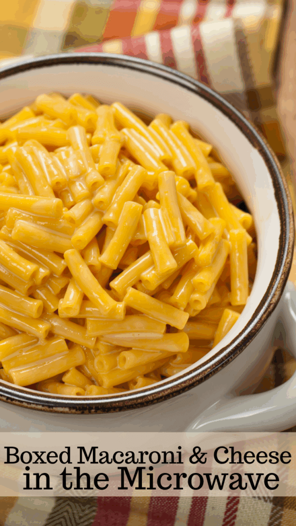 Close up of a bowl with a brown edge full of kraft macaroni and cheese on top of a plaid towel. 