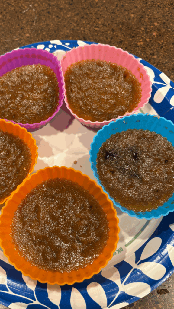 Mini Pumpkin Pies just cooked in the microwave on a blue floral paper plate on a brown countertop. 